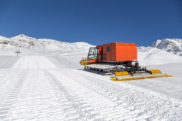 Snowplow in the mountains prepairing piste