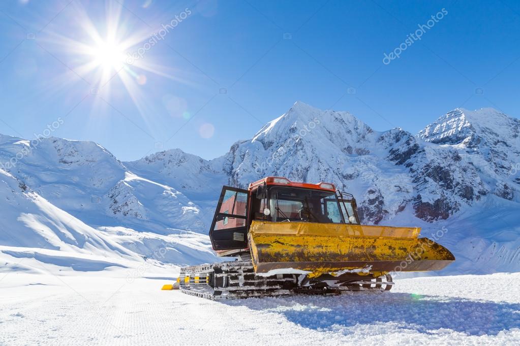 Snowplow in the mountains prepairing piste