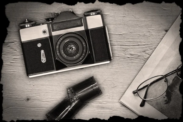Old manual camera with newspaper and film — Stock Photo, Image