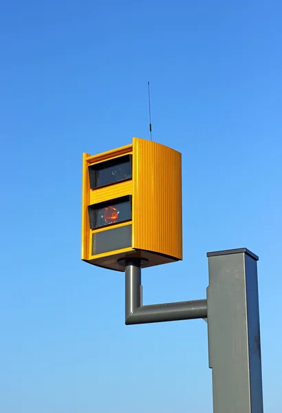 Uma câmera de monitoramento de velocidade de tráfego, contra um céu azul brilhante . — Fotografia de Stock