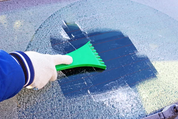 Cleaning frozen car window from the ice — Stock Photo, Image