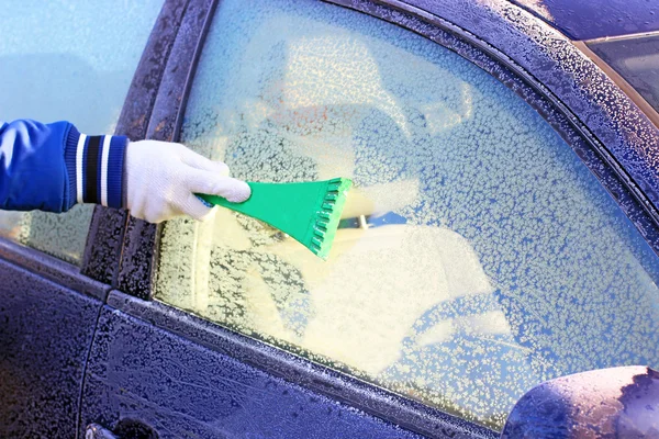 Cleaning frozen car window from the ice — Stock Photo, Image