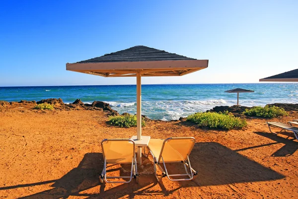 Laganas, Griekenland - 23 Aug 2015: Paraplu's en zonneterrassen van het zandstrand van de banaan op Zakynthos, Griekenland. Banaan is het grootste strand van Zakynthos eiland. — Stockfoto