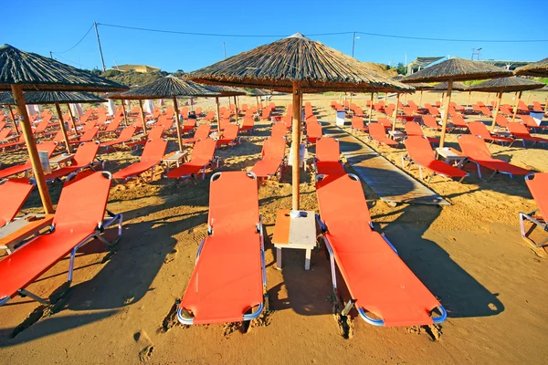 Laganas, Griekenland - 23 Aug 2015: Paraplu's en zonneterrassen van het zandstrand van de banaan op Zakynthos, Griekenland. Banaan is het grootste strand van Zakynthos eiland. — Stockfoto
