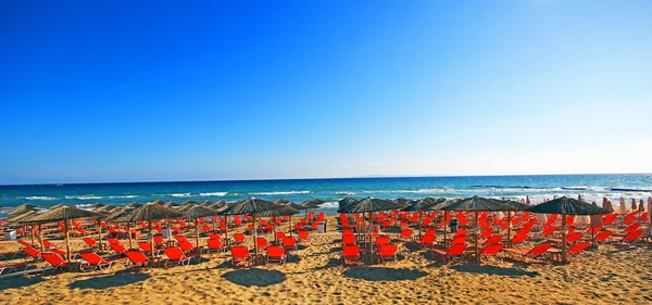 Paraplu's en zonneterrassen van het zandstrand van de banaan op Zakynthos, Griekenland. Banaan is het grootste strand van Zakynthos eiland. — Stockfoto