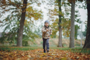 Sonbahar ormanında oynayan çocuk
