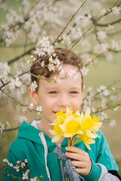 Niño Con Ramo Narcisos Bajo Árbol Floreciente —  Fotos de Stock