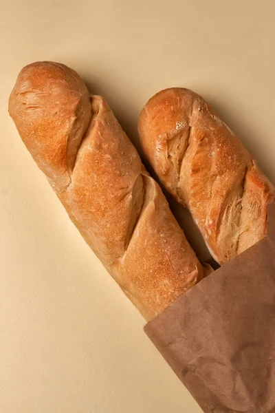 Französisches Baguette Einer Papiertüte Und Ähren Auf Einer Hellen Tischplatte — Stockfoto