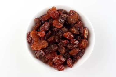 Beyaz arka planda kuru üzümlü beyaz kase ve metin için boşluk, üst görünüm.