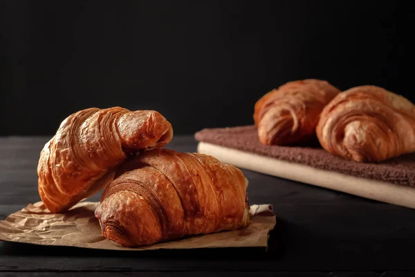 Tasse Cappuccino und Croissant auf dunklem Tisch — Stockfoto