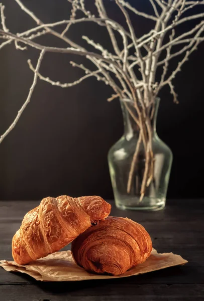 Kopje cappuccino koffie en croissant op donkere tafel — Stockfoto