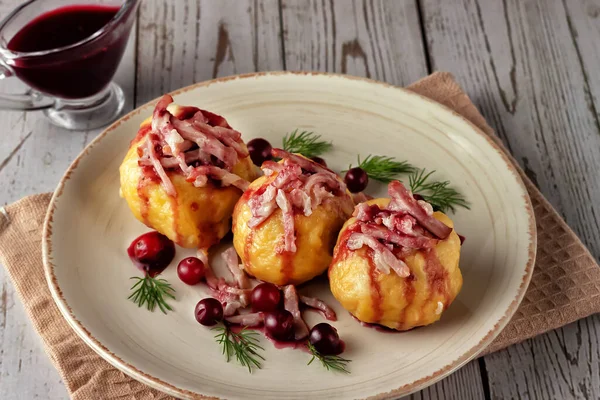 Hafif arkaplanda kızılcık soslu İsveç patatesli börek.