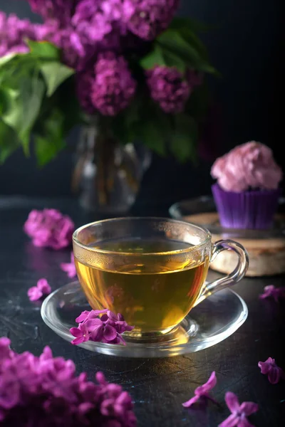 在紫丁香的背景下 一杯茶与松饼加奶油奶酪奶油 — 图库照片
