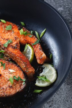 Limonlu, baharatlı ve limonlu ızgara somon bifteği, yakın plan. Lezzetli pişmiş somon filetosu..