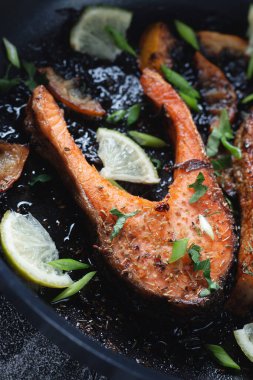 Limonlu, baharatlı ve limonlu ızgara somon bifteği, yakın plan. Lezzetli pişmiş somon filetosu..