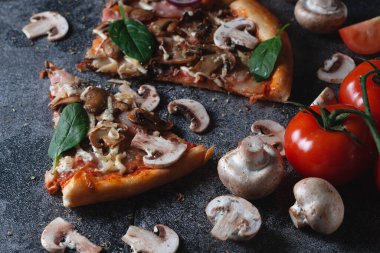 Mantarlı, jambonlu, domatesli, peynirli, soğanlı ve otlu ev yapımı İtalyan pizzası.