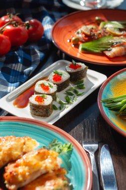 İştah açıcı ev yapımı suşi yuvarlakları masada güneşli ve güzel bir ortamda. 