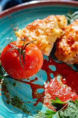 Masanın üzerinde nefis bir şekilde pişmiş domates ve tavuk güveci var. 