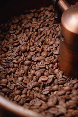 Kahve üretimi. Kavrulmuş dönen soğutucu profesyonel makineler ve taze kahverengi kahve çekirdekleri.