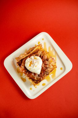 Nefis bir kahvaltı. Kırmızı arka planda çırpılmış yumurta.