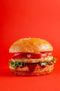 Kırmızı arka planda yeşil biberli lezzetli bir burger. Peynirli ve iki köfteli leziz sağlıksız burger. Fast food, sağlıksız gıda konsepti