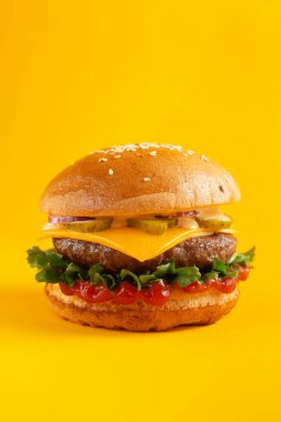 Sarı arka planda hamburger. Fast food, abur cubur kavramı