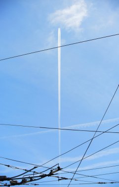Uçak contrail tramvay hattı kabloları üzerinde gökyüzü hizalama