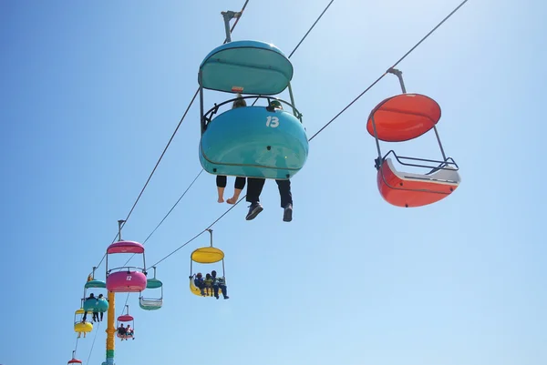 People riding a colorful cableway — Stock Photo, Image