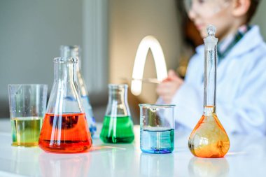 Kimya laboratuvarı. Kimyasal bir deney yapıyorum. Laboratuvarda yapılan deneyler. Şişeler ve renkli sıvıyla test tüpleri. Çocuk bir kimya laboratuvarında deney yapıyor. Bilim..
