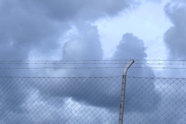 Metalik ağ kara fırtınalı bulutlara karşı gökyüzü. Umutsuzluk ve korku kavramları