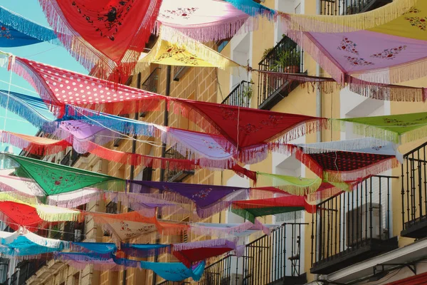 La Latina bölgesindeki caddenin dışındaki balkonların arasına dizilmiş klasik İspanyol şalları. Dekoratif ortam, şenlik havası. Madrid, İspanya
