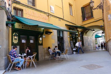 Madrid, İspanya - 15 Mayıs 2021: San Gines çikolata terasında kahve içen gençler. 100 yıllık tarihi olan bir bar ünlü churro ve porra servis eder.