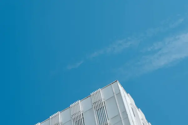 雲と青い空を背景に白い建物の落下角を持つ最小限の背景 — ストック写真