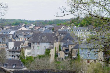 Resimli bir vadi, geleneksel taş binaları ve çatıları olan eski bir köyü gözler önüne seriyor. Sahne, bulutlu bir bahar gününde yeşil ağaçların arasında sakin bir atmosfer yakalıyor..