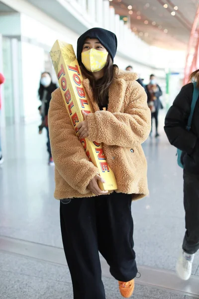 中国人女優の劉雲は 11月2020の空港でマスクと帽子で現れる珍しい9キロのタブレロンチョコレートを保持しています — ストック写真