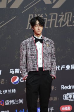 Chinese actor, dancer, singer, rapper, host, and professional motorcycle racer Wang Yibo, dressing in a Chanel suit at the red carpet for the 2020 Tencent Video Star Awards in Nanjing City, east China's Jiangsu Province, 20 December 2020.   clipart