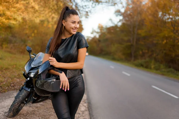 Feminino Motociclista Fica Perto Motocicleta Beira Estrada Segurando Capacete — Fotografia de Stock