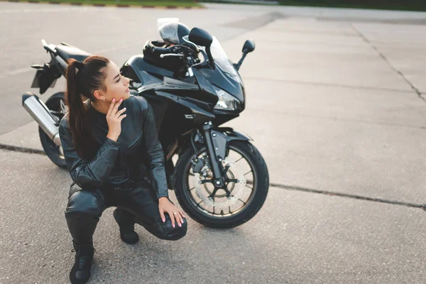 摩托车旁边穿着皮衣的摩托女孩 — 图库照片