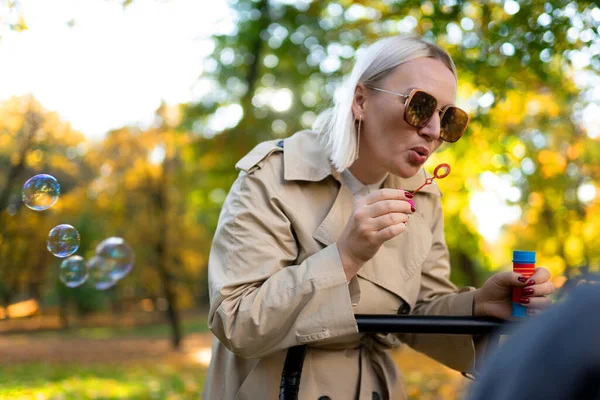 Mother Blows Soap Bubbles Entertain Baby Stroller — Stock Photo, Image