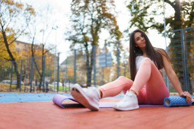 Sportif kız yoga minderinde dinleniyor.