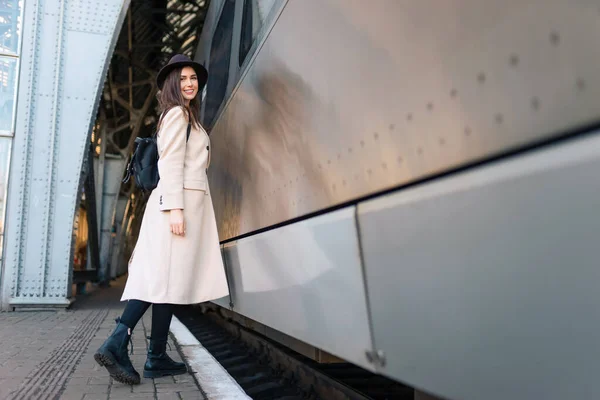 駅のプラットフォーム上のバックパック付きの美しい旅行者 電車の近くの若い女性 — ストック写真