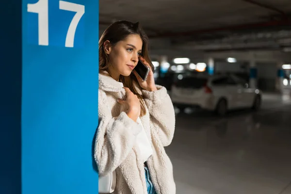 Стильная Девушка Подземной Парковке Разговаривает Телефону Прислонившись Стене — стоковое фото