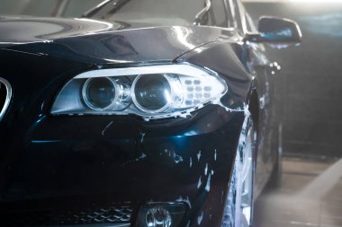 Araba yıkamada, basınçlı yıkama makinesiyle arabadan köpük boşaltılıyor.