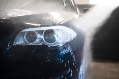 Araba yıkamada, basınçlı yıkama makinesiyle arabadan köpük boşaltılıyor.