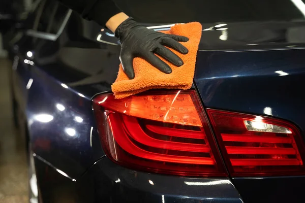 Detailing master wipes the car body with microfiber. Auto detiling concept