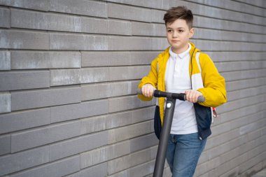 Yakışıklı genç şehirde elektrikli scooterla geziyor.
