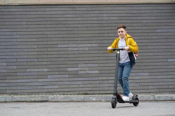 Adolescente Moderno Com Passeios Mochila Scooter Elétrico Fundo Parede Tijolo — Fotografia de Stock