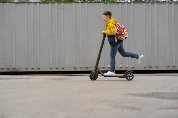 Moderne Tiener Met Rugzak Rijdt Elektrische Scooter Jongen Komt Terug — Stockfoto