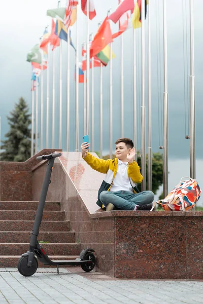 Підліток Сидить Біля Адміністративної Будівлі Тлі Сільських Прапорів Хвиль Смартфон — стокове фото