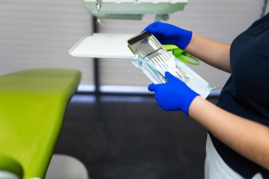 Diş hekimi mühürlü steril diş aletlerini açıyor